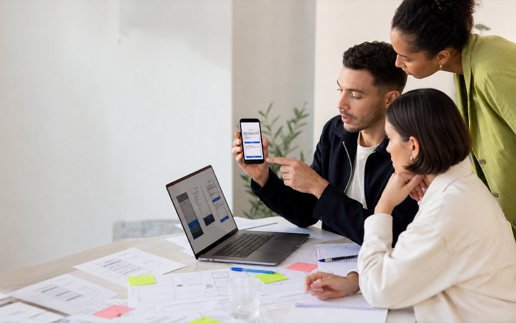 Small ecommerce team comparing a purchase journey on phone and laptop